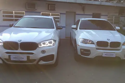 Duas BMW brancas em frente à Pintura de Prata