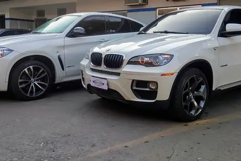Duas BMW X6 brancas no pátio da oficina