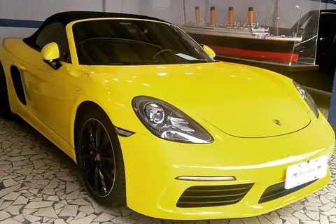 Porsche conversível amarelo dentro da oficina