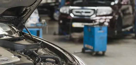 Carro com o capô aberto em uma oficina mecânica