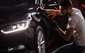 Profissional fazendo o polimento da pintura de um carro preto
